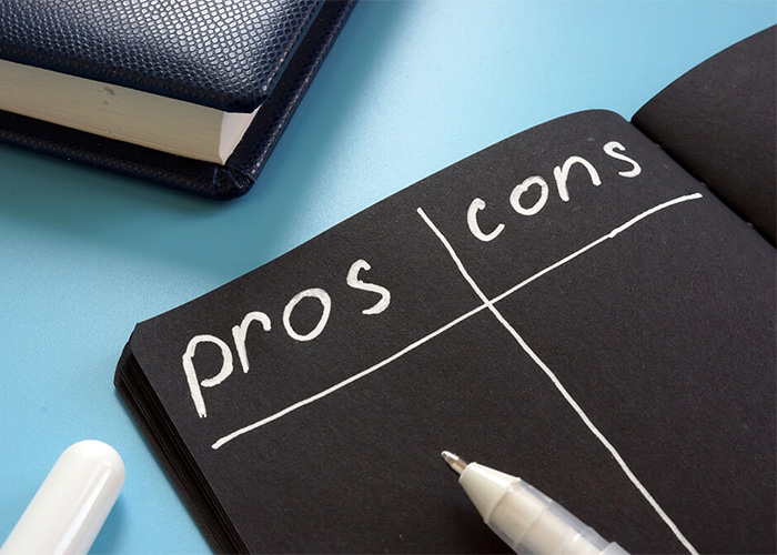 illustration of a pros and cons list on black paper with white text